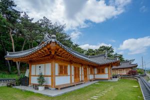 a small building with a roof in a park at Hanok Stay Yeoyeo in Gyeongju