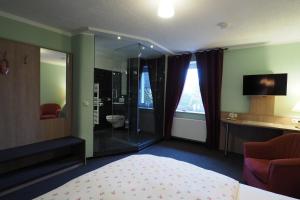a hotel room with a bed and a shower at Stelinger Hof Hotel Münkel in Hannover