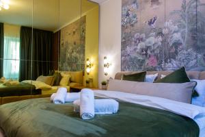 a bedroom with a large bed with towels on it at The Royal Palace Luxury Suite by Sattal in Bucharest