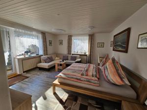 a bedroom with a bed and a living room at Pension Haus Erika in Cuxhaven