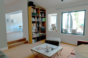 ein Wohnzimmer mit einem Couchtisch und einem Bücherregal in der Unterkunft Villa art de vivre & absolute calm Baux de Provence in Les Baux-de-Provence