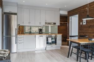 una cocina con armarios blancos y una mesa con sillas. en Nice apartment in Järvsö by the slopes, en Järvsö 13 fotos más