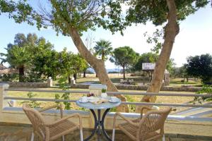 a table and chairs on a patio with a tree at Electra Studios in Palaiochora