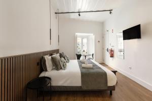 a bedroom with a large bed and a television at Solar das Termas in Caldas da Rainha