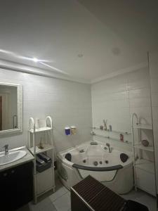 a bathroom with a tub and a sink and a mirror at Paradise in Bin Rhilouf