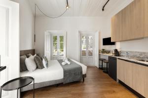 a bedroom with a large bed and a kitchen at Solar das Termas in Caldas da Rainha