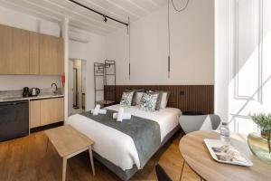 a bedroom with a bed and a table and a kitchen at Solar das Termas in Caldas da Rainha