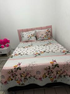 ein Schlafzimmer mit einem Bett mit geblümter Bettdecke in der Unterkunft Janga Paulista-Pe in Paulista