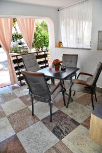a dining room with a table and chairs on a tile floor at Apartments Vretenar in Novigrad Istria