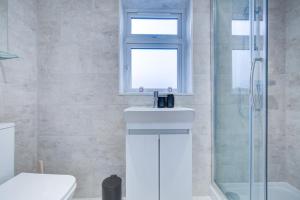 ein Badezimmer mit Toilette, Waschbecken und Dusche in der Unterkunft Sleek 3 Bedroom 6 Beds 2 Bath Home in Colchester + 27 Fotos