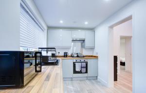 eine Küche mit weißen Schränken und einem schwarzen Kühlschrank in der Unterkunft Sleek 3 Bedroom 6 Beds 2 Bath Home in Colchester