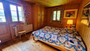 a bedroom with a bed and a lamp and a chair at Le Bouquetin - Chalet familial- 8 personnes in Evolène