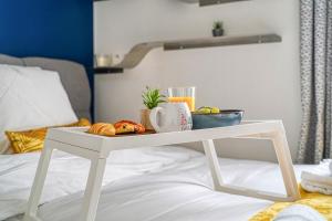 una mesa blanca con una bandeja de comida en la cama en Reflet Royal - 10 min de Paris - Netflix, en Alfortville 13 fotos más