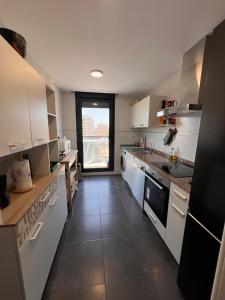 a kitchen with white cabinets and a tile floor at Apartment in campello Beach in El Campello