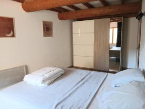 a white bed in a room with a mirror at Maison de village à Riez de 87m2 in Riez