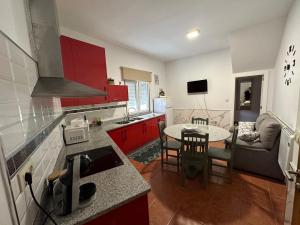 a kitchen with red cabinets and a table in a kitchen at Pisos A Barca in Muxia