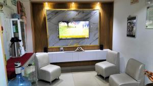 a waiting room with two chairs and a tv on the wall at Hotel plaza centro in Florencia
