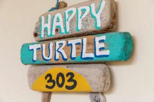 a sign that says happy turtle with three rocks at Villa Happy Turtle with a spectacular ocean view in Kralendijk