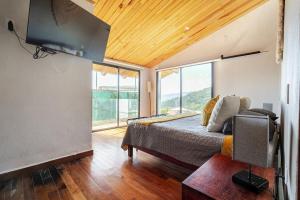 a bedroom with a bed and a large window at LUXO Casa en Valle de Bravo con jacuzzi y espectacular vista al lago in Valle de Bravo