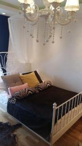 een bed in een slaapkamer met een kroonluchter bij Visnja Apartment in Kopaonik