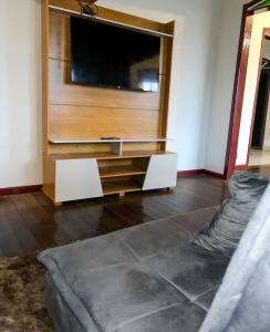 a living room with a entertainment center with a flat screen tv at Pouso Canaa in Ouro Preto