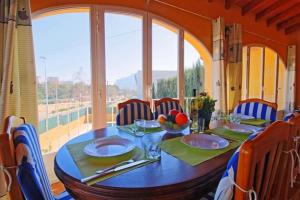 Una mesa de comedor con sillas y una gran ventana. en confortable villa at only 100 meter from the beach, supermarkets and the restaurants, en Calpe