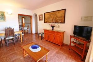 una sala de estar con un televisor y una mesa en confortable villa at only 100 meter from the beach, supermarkets and the restaurants, en Calpe