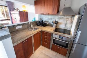 a kitchen with wooden cabinets and a stainless steel refrigerator at Aqua Marina in Kralendijk