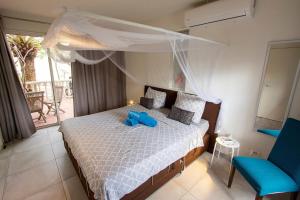 a bedroom with a bed with a blue stuffed animal on it at Aqua Marina in Kralendijk