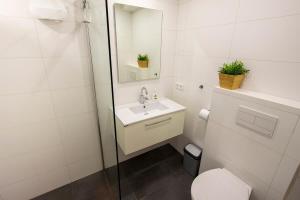 a bathroom with a toilet and a sink and a shower at Aqua Marina in Kralendijk