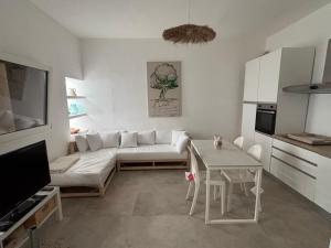ein Wohnzimmer mit einer weißen Couch und einem Tisch in der Unterkunft Casa Ulivo in Capilungo