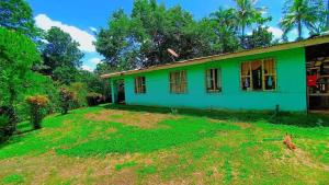 a green house with a dog in front of it at Casa La Esperanza in Chachagua
