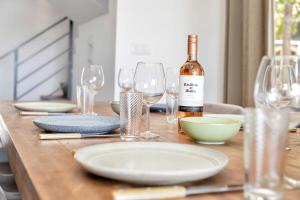 a wooden table with glasses and a bottle of wine at Casa Pimienta in Water Villas in Kralendijk +31 photos