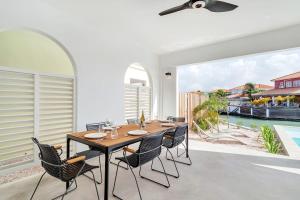 a dining room with a table and chairs and a large window at Kas Jasabon in Water Villas in Kralendijk