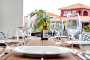 a bottle of wine sitting on a wooden table with wine glasses at Kas Jasabon in Water Villas in Kralendijk