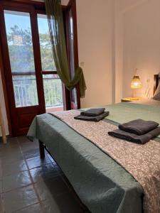 a bedroom with a bed with two towels on it at Aether House Αιθήρ in Toroni