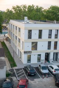 un edificio de apartamentos con coches aparcados en un aparcamiento en Brizo Boutique Hotel, en Mamaia