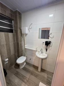 a bathroom with a toilet and a sink at Villa Germânia - Pousada da Luiza in Santa Cruz do Sul