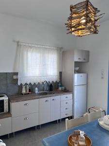 una cucina con mobili bianchi, un lavello e una finestra di North eye ad Apóllon