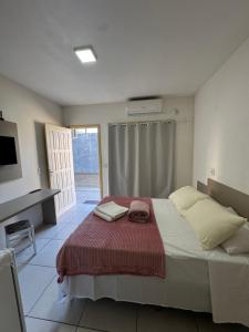 a bedroom with a bed with a red blanket at Villa Germânia - Pousada da Luiza in Santa Cruz do Sul