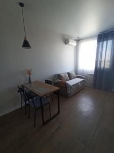 een woonkamer met een tafel en een bank bij Апартаменты в Одессе у моря на Лузановке in Odessa