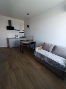 een woonkamer met een bank en een tafel bij Апартаменты в Одессе у моря на Лузановке in Odessa