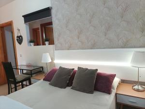 1 dormitorio con cama blanca con almohadas y espejo en Casa cerca del campo y la ciudad, en Santidad