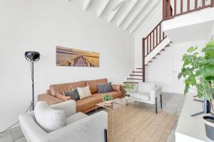 ein Wohnzimmer mit einer Couch und einer Treppe in der Unterkunft Caribbean Court Apartment Djòdjò in Kralendijk