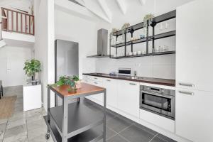 eine Küche mit weißen Schränken und einem Holztisch in der Unterkunft Caribbean Court Apartment Djòdjò in Kralendijk + 22 Fotos