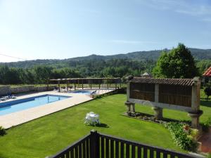 a backyard with a swimming pool and a fence at Quinta do Burgo - Nature Hotel in Amares