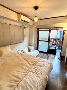 a bedroom with a large bed and a couch at ペットと泊まれる Tatami & B 池上 202 2DK 40m2 in Tokyo