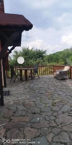 Una mesa de picnic y sillas en un patio de piedra. en Family Mountain Cottage, en Cârţişoara