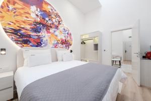 una camera da letto con un letto bianco e un quadro sul muro di Hotel Eleven a Sarajevo