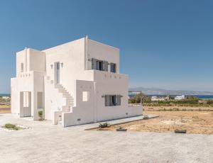 MaragkasにあるVilla vista azzurraのビーチに建つ階段のある白い家